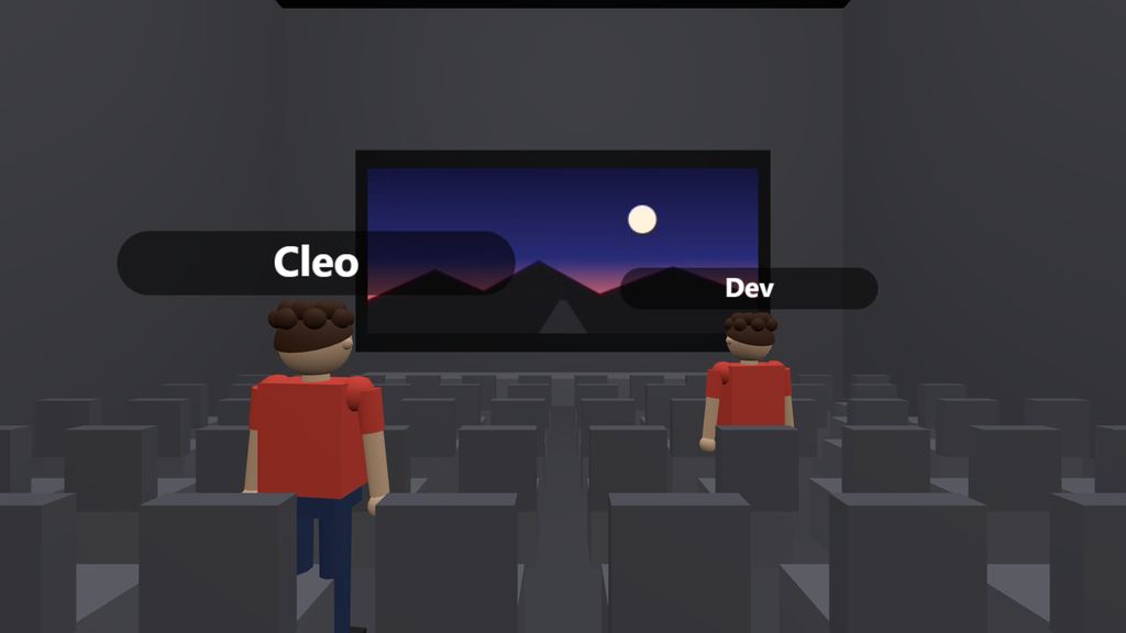 Game screenshot: two friends standing between the rows of Theater 1 while a show plays on the screen